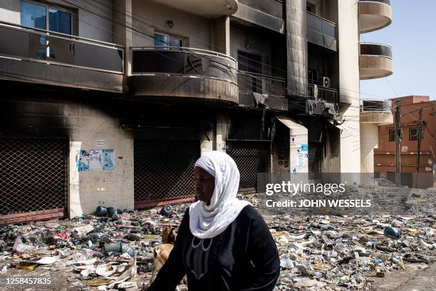 Woman walks past a burned out and ransacked supermarket in the popular Yoff Neighbourhood of Dakar, on June 5 as protest calmed down four days after...