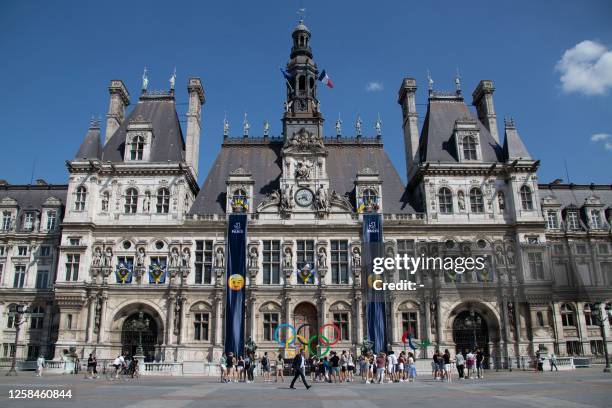 Pedestrians walk past the Paris' "Hotel de Ville" as banners with winking emojis are displayed on the facade, in Paris, on June 5, 2023. Paris' town...
