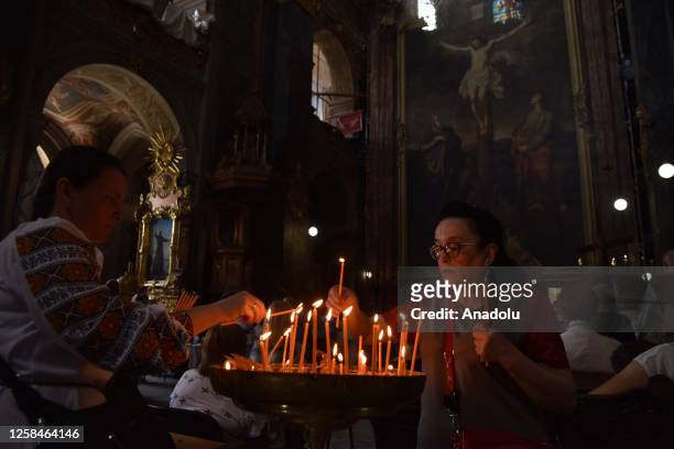 Women light candles in the Garrison Church of the Holy Apostles Peter and Paul in Lviv, Ukraine on June 5, 2023. Today, the Garrison Church of the...