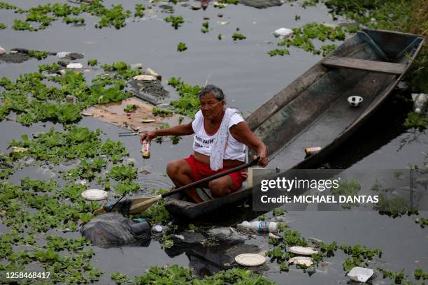 Woman collects aluminum cans on her boat at the Educandos creek in Manaus, Amazonas state, Brazil on June 5 during the World Environment Day.