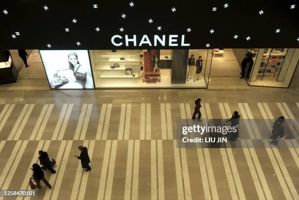 Shoppers walk past a top fashion boutique at a shopping mall in Beijing on January 15, 2009. Foreign direct investment in China rose 23.6 percent in...