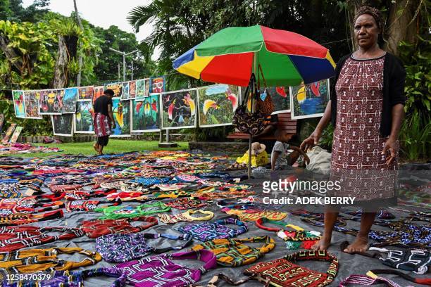 This picture taken on May 20, 2023 shows a woman selling traditional Papua New Guinean "Bilum" bags at a craft market in Port Moresby. The boutique...
