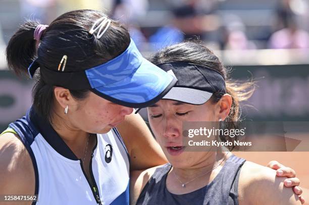 Japanese tennis player Miyu Kato appears in shock as her Indonesian partner Aldila Sutjiadi wraps an arm around her shoulders, after the pair were...