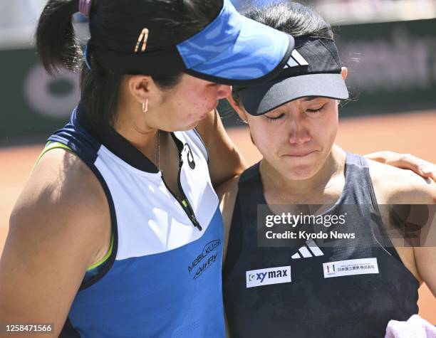 Japanese tennis player Miyu Kato appears in shock as her Indonesian partner Aldila Sutjiadi wraps an arm around her shoulders, after the pair were...