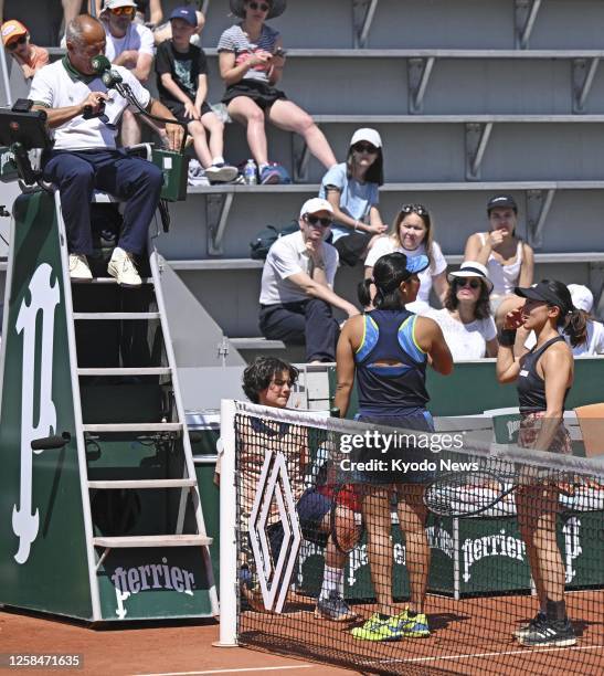 Japanese tennis player Miyu Kato and her Indonesian partner Aldila Sutjiadi talk with the umpire during a women's doubles third round match at the...