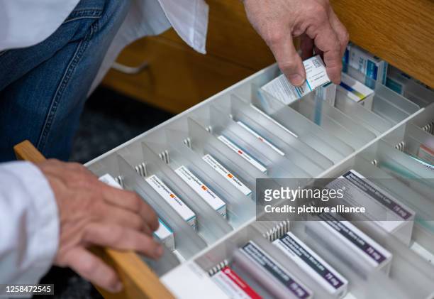 June 2023, Berlin: A pharmacist retrieves a medication package containing antidepressants from a drawer in a pharmacy. Photo: Monika Skolimowska/dpa
