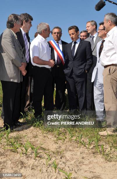 French President Nicolas Sarkozy speaks with farmer Philippe Blouin on one of his fields, on May 21, 2010 in Bouglon, southwestern France, during his...