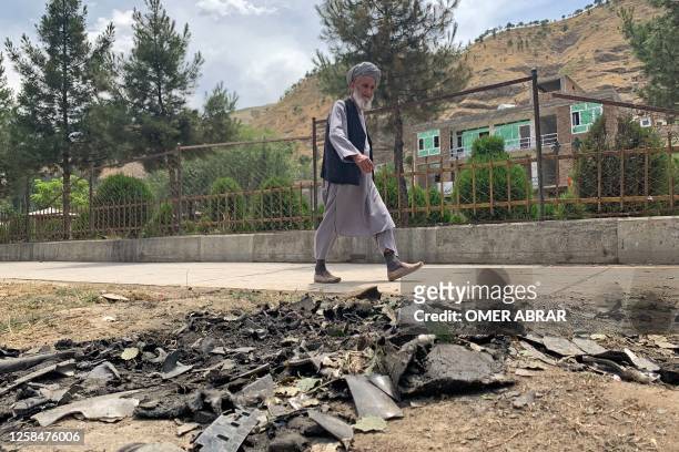 Man walks past the site of a suicide attack along the roadside in Faizabad district of Badakhshan province on June 6, 2023. The acting governor of an...