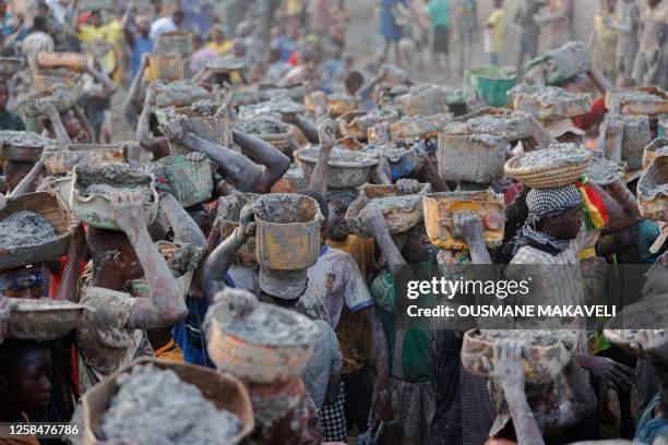 People carry buckets of mud used to re-plaster the Great Mosque of Djenne in central Mali on June 4, 2023. Thousand of people from Djenne gather each...