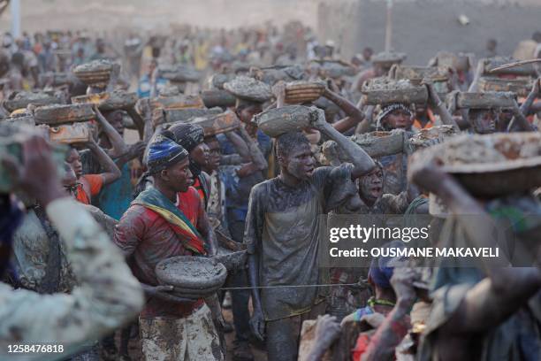 People carry buckets of mud used to re-plaster the Great Mosque of Djenne in central Mali on June 4, 2023. Thousand of people from Djenne gather each...