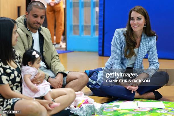 Britain's Catherine, Princess of Wales meets members of a group accessing the early years services during a visit to the Windsor Family Hub in...