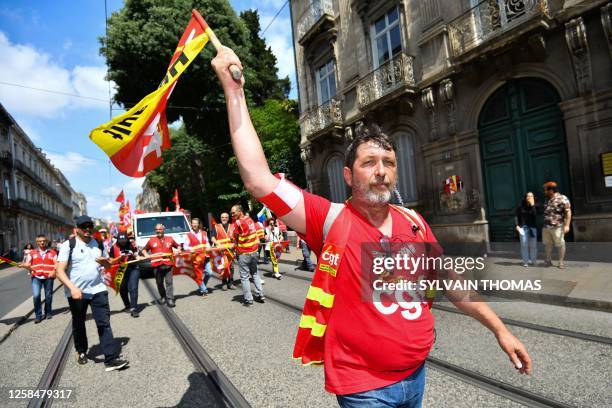 Protestor holds a General Confederation of Labour union flag during a demonstration on the 14th day of action after the government pushed a pensions...