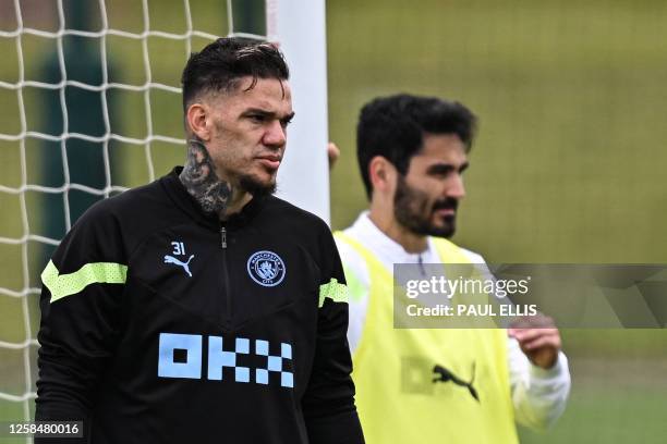 Manchester City's Brazilian goalkeeper Ederson and Manchester City's German midfielder Ilkay Gundogan react as they take part in a team training...