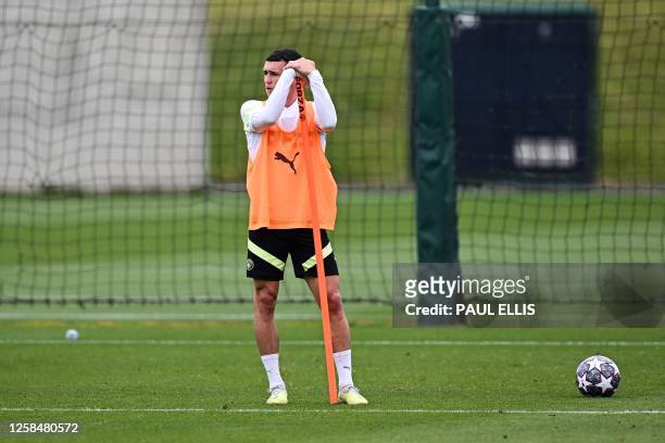 Manchester City's English midfielder Phil Foden reacts as he takes part in a team training session at Manchester City training ground in Manchester,...