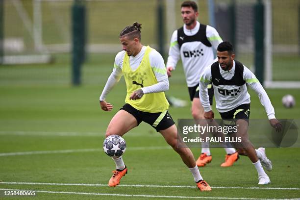 Manchester City's English midfielder Kalvin Phillips and Manchester City's Algerian midfielder Riyad Mahrez take part in a team training session at...