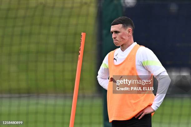 Manchester City's English midfielder Phil Foden reacts as he takes part in a team training session at Manchester City training ground in Manchester,...