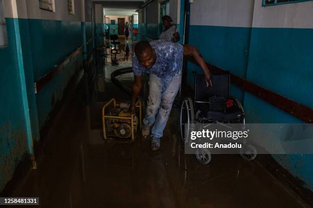 Worker pushes a generator at the Saint-Croix Hospital after flooding in the commune of Leogane, Haiti on June 5, 2023.