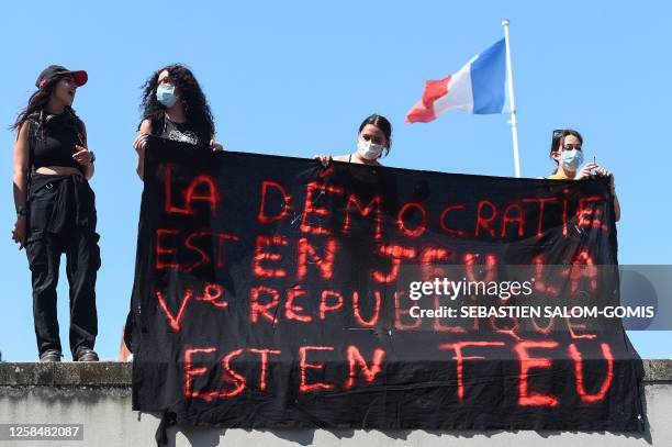 Protesters hold a banner reading « Democracy is at stake , the 5th Republic is on fire » during a demonstration on the 14th day of action after the...