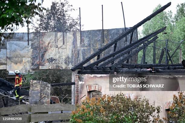 Firefighter walks amid debris amid the destroyed structure of a building after a fire broke out and was extinguished in the Karls Erlebnis-Dorf...