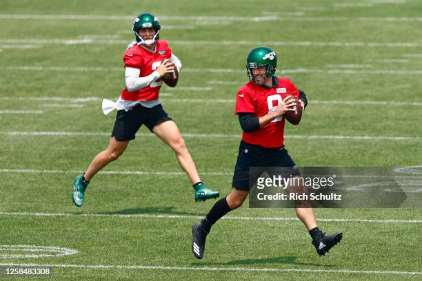 Quarterbacks Aaron Rodgers and Zach Wilson of the New York Jets drop back to pass during the team's OTAs at Atlantic Health Jets Training Center on...