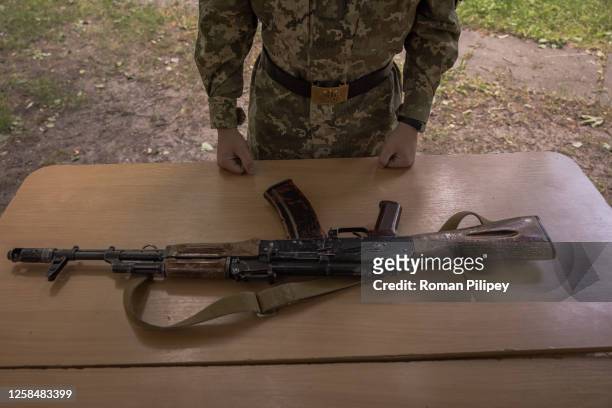 Young Ukrainian cadet competes in assembling a weapon during a mass military education quest at State Lyceum 'Cadet Corps' on June 6, 2023 in Kyiv,...