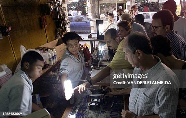 Residents of Rio de Janeiro, Brazil, stand in line to buy fluorescent lamps 01 June 2001, in a store of electrical supplies. Residentes de Rio de...