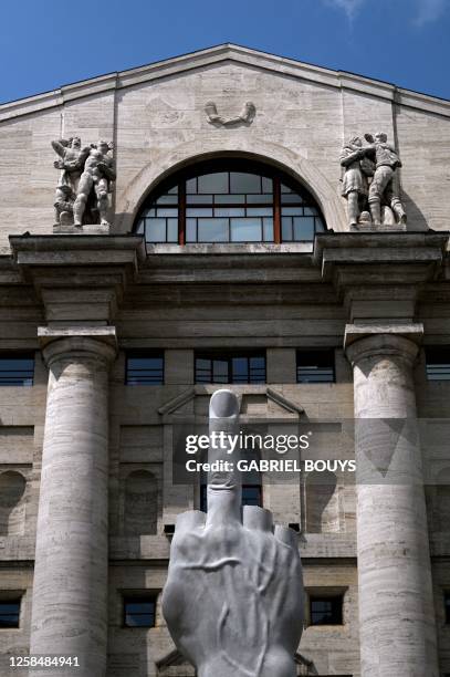 Sculpture by Italian artist Maurizio Cattelan, entitled "L.O.V.E" is pictured outside Palazzo Mezzanotte, Italy's stock exchange building, on June...