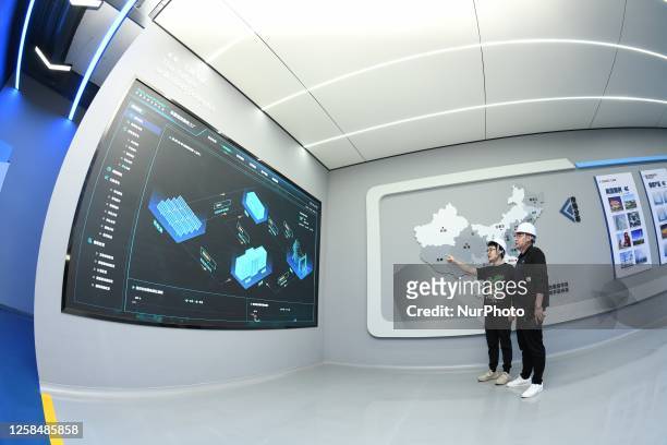 Technician looks at an energy intelligent management system at an intelligent processing center in Hai 'an city, Jiangsu province, China, June 6,...