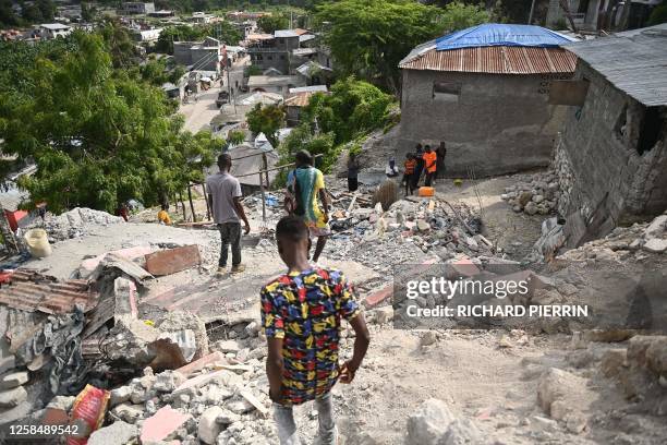 People walk amongst damaged buildings in Jeremie, Haiti, after an earthquake hit western Haiti on June 6, 2023. An earthquake shook parts of western...