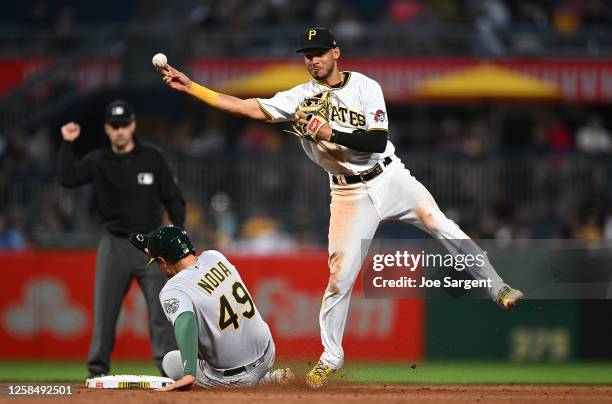 Tucupita Marcano of the Pittsburgh Pirates turns a double play over Ryan Noda of the Oakland Athletics during the sixth inning at PNC Park on June 6,...