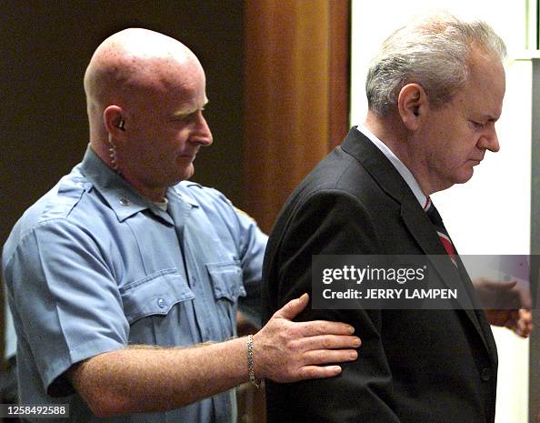 Former Yugoslav president Slobodan Milosevic is led into the... News ...