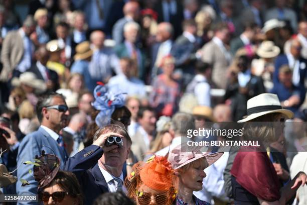 Racegoers enjoy the sunshine on the first day of the Epsom Derby Festival horse racing event in Surrey, southern England on June 2, 2023.