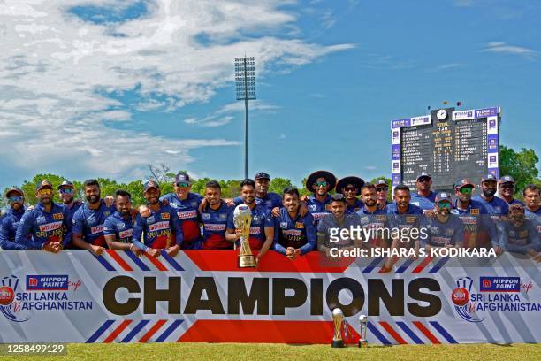 Sri Lanka's players pose with the trophy after winning the third and final one-day international cricket match against Afghanistan at the Mahinda...