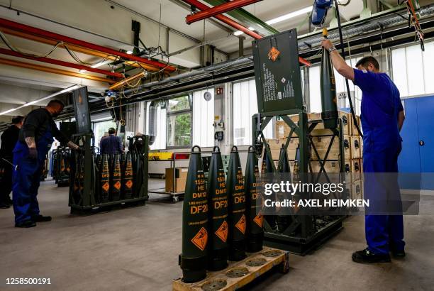 Technicians of German armaments company and automotive supplier Rheinmetall work on 155mm ammunition that will be delivered to Ukrainian Forces for...