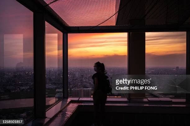 Woman visits the I-link Town observatory as skylines of Tokyo and Ichikawa are seen during the evening hour in Ichikawa city, Chiba prefecture, east...