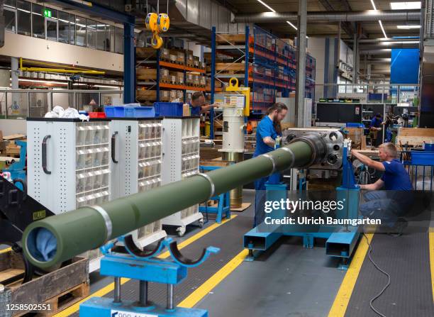 Technicians from the armaments group Rheinmetall AG work on gun barrels for the Leopard 2A4 battle tank in one of the group's production hall on June...