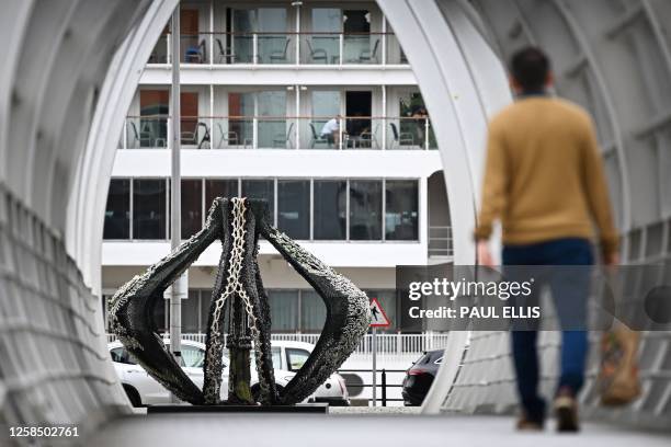 Visitor walks past the monumental sculpture "Ali sa be sa be" by artist Eleng Luluan, from the Kucapungane community from Taiwan, made of steel and...