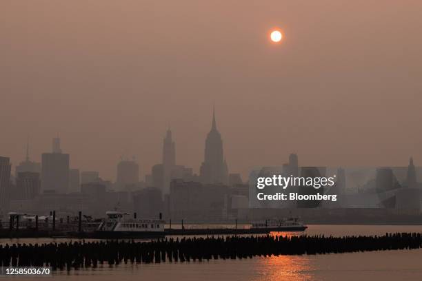 Buildings in the Manhattan skyline shrouded in smoke from Canada wildfires at sunrise in Jersey City, New Jersey, US, on Wednesday, June 7, 2023. New...