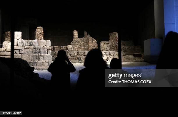 Poeple photograph the foundations remains of the old royal fortress of Madrid during an an open visit to the media to the Galeria de las Colecciones...