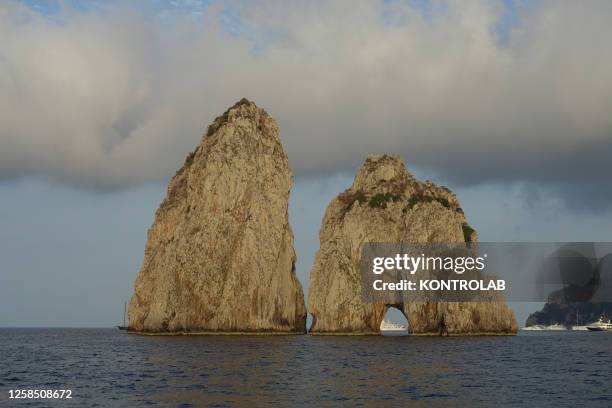 View of the Capri Island, from sea, Faraglioni rock formation, in the bay of Naples, Mediterranean Sea.