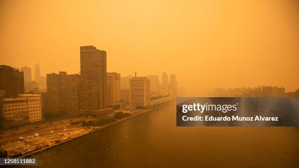 The tramway to Roosevelt Island crosses the East River as smoke from Canadian wildfires casts a haze over the area on June 7, 2023 in New York City....