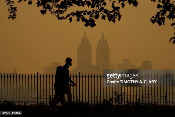 People walk in Central Park as smoke from wildfires in Canada cause hazy conditions in New York City on June 7, 2023. Smoke from Canada's wildfires...