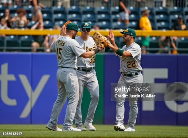 Seth Brown, JJ Bleday and Ramon Laureano of the Oakland Athletics celebrate after defeating the Pittsburgh Pirates 9-5 during inter-league play at...