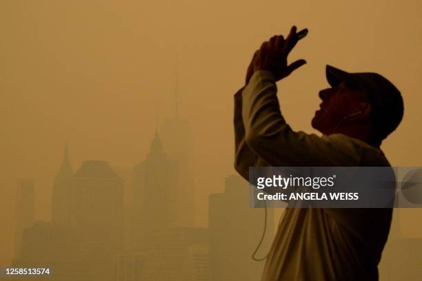 People take photos as smoke from the wildfires in Canada cause hazy conditions in New York City on June 7, 2023. Smoke from Canada's wildfires has...