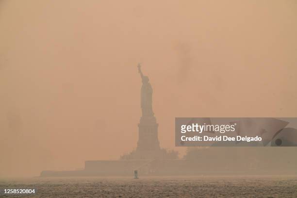 Smoky haze from wildfires in Canada envelops the Statue of Liberty in Upper Bay on June 7, 2023 in New York City. New York topped the list of most...