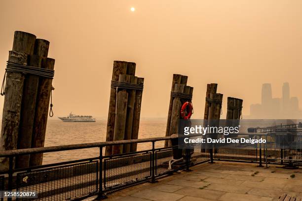 Boat passes by Battery Park amid a smoky haze from wildfires in Canada on June 7, 2023 in New York City. New York topped the list of most polluted...