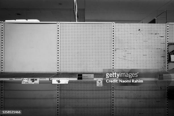 no toilet paper or hand sanitiser - empty supermarket shelf due to panic buying during covid-19 pandemic - shelf stock pictures, royalty-free photos & images