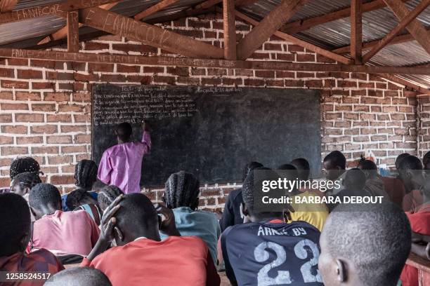 Children in a fifth grade class learn a text written by a teacher on the blackboard inside Central African Republic's largest displacement camp in...