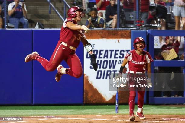 Alyssa Brito and Rylie Boone of the Oklahoma Sooners react after Brito scored a run during the Division I Women's Softball Championship against the...