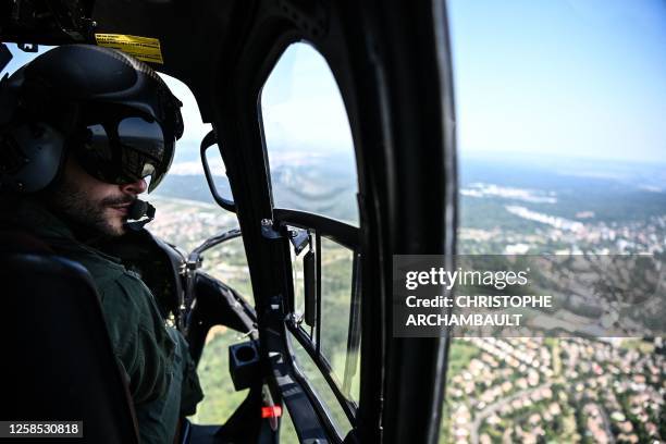 Pilot of a French army Fennec helicopter performs a reconnaissance flight ahead of the July 14 air parade above Paris and its western suburbs on June...